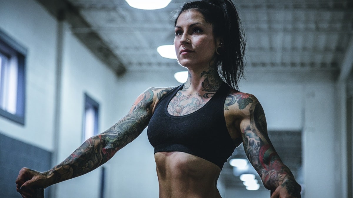 woman wearing black sports bra with tattoos